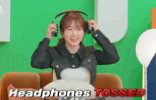 a woman wearing headphones with the words " headphones tossed " behind her