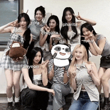 a group of girls are posing for a picture and one of them is holding a stuffed animal