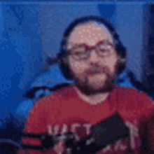 a man with a beard and glasses is playing a video game .