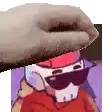 a cartoon character wearing sunglasses and a hat is being held by a hand .