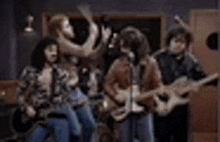 a group of people are playing guitars in a recording studio .