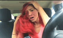 a woman with red hair sitting in a car