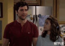 a man and a girl are standing in front of a netflix logo