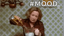 a woman is pouring a bottle of alcohol into a glass .