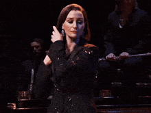 a woman wearing a black jacket with a brooch that says ' i love you ' on it
