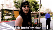 a woman says this broke my heart while wearing a black hat
