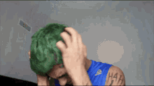 a man with green hair and a tattoo that says ' hah ' on his arm