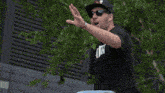 a man wearing sunglasses and a hat has a bracelet around his wrist