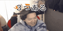 a man wearing a tie dye nike hoodie is smiling in front of a sign that says 3