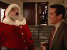 a man in a suit and tie is standing next to a santa claus