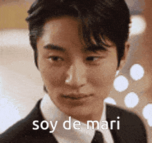 a close up of a man in a suit and tie with the words soy de mari on his face .