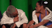 a man and a woman are sitting next to each other on a green background .