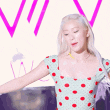 a woman in a green polka dot dress is dancing