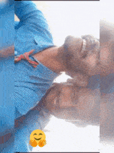 a man in a blue plaid shirt is smiling next to another man with a smiley face on his face