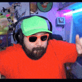 a man with a beard wearing a green hat and orange sunglasses