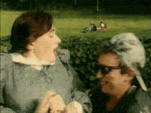 a woman with a bird on her head talks to a man