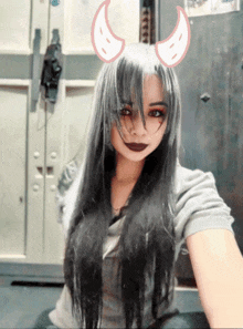 a girl with long black hair has devil horns on her head
