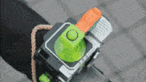 a green and orange device with a button that says ' a ' on it
