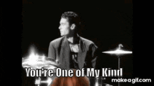 a man with long red hair is playing drums and says you 're one of my kind .