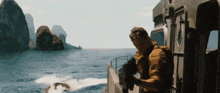 a man is holding a gun on a boat in the water