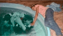 a girl in a pink shirt is laying in the water