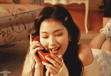 a woman laying on the floor talking on a red phone with ccchuu written on the bottom
