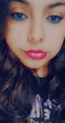 a close up of a woman 's face with blue eyeshadow