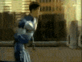 a man in a superhero costume is running down a street in front of a building .