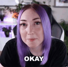 a woman with purple hair says okay in front of her face