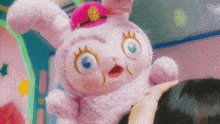 a close up of a stuffed animal wearing a pink hat and a scarf .