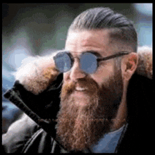 a man with a beard wearing sunglasses and a jacket