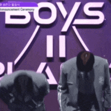 two men are bowing in front of a sign that says boys ii