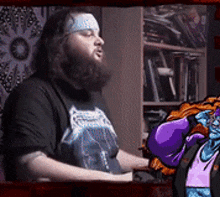 a man with a beard wearing a black shirt with a metallica logo on it