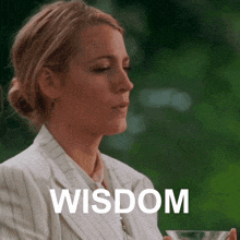 a woman in a striped suit is holding a glass with the word wisdom on it