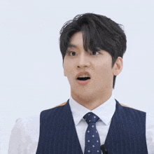 a man in a suit and tie looks surprised with his mouth open