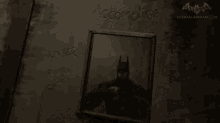 a black and white photo of batman sitting on a table .