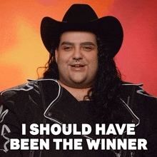a man with long hair wearing a cowboy hat and a jacket says i should have been the winner