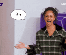 a woman in a plaid shirt is laughing with a speech bubble that says mu on it