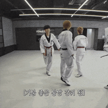 a man in a taekwondo uniform is holding hands with two other men