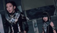 two women dressed in costume are standing next to each other in a room .