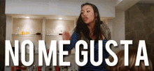 a woman stands in front of a sign that says " no me gusta "