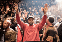 a man wearing a red sweatshirt that says feel like pablo
