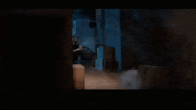 a man in a black shirt is standing in a dark room with his arms outstretched