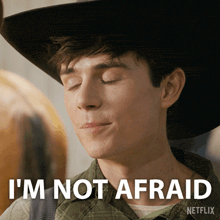 a young man wearing a cowboy hat says " i 'm not afraid "