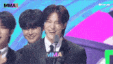 a man in a suit and tie stands in front of a microphone that says mma on it