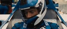 a man wearing a sparco helmet is sitting in a car