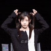 a girl in a black and white sweater holds her hair