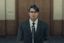 a man in a suit is speaking into a microphone