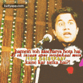 a man stands in front of a microphone with the words hamein toh aascharya hota hai written on it