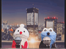 two stuffed animals holding microphones in front of a city skyline at night